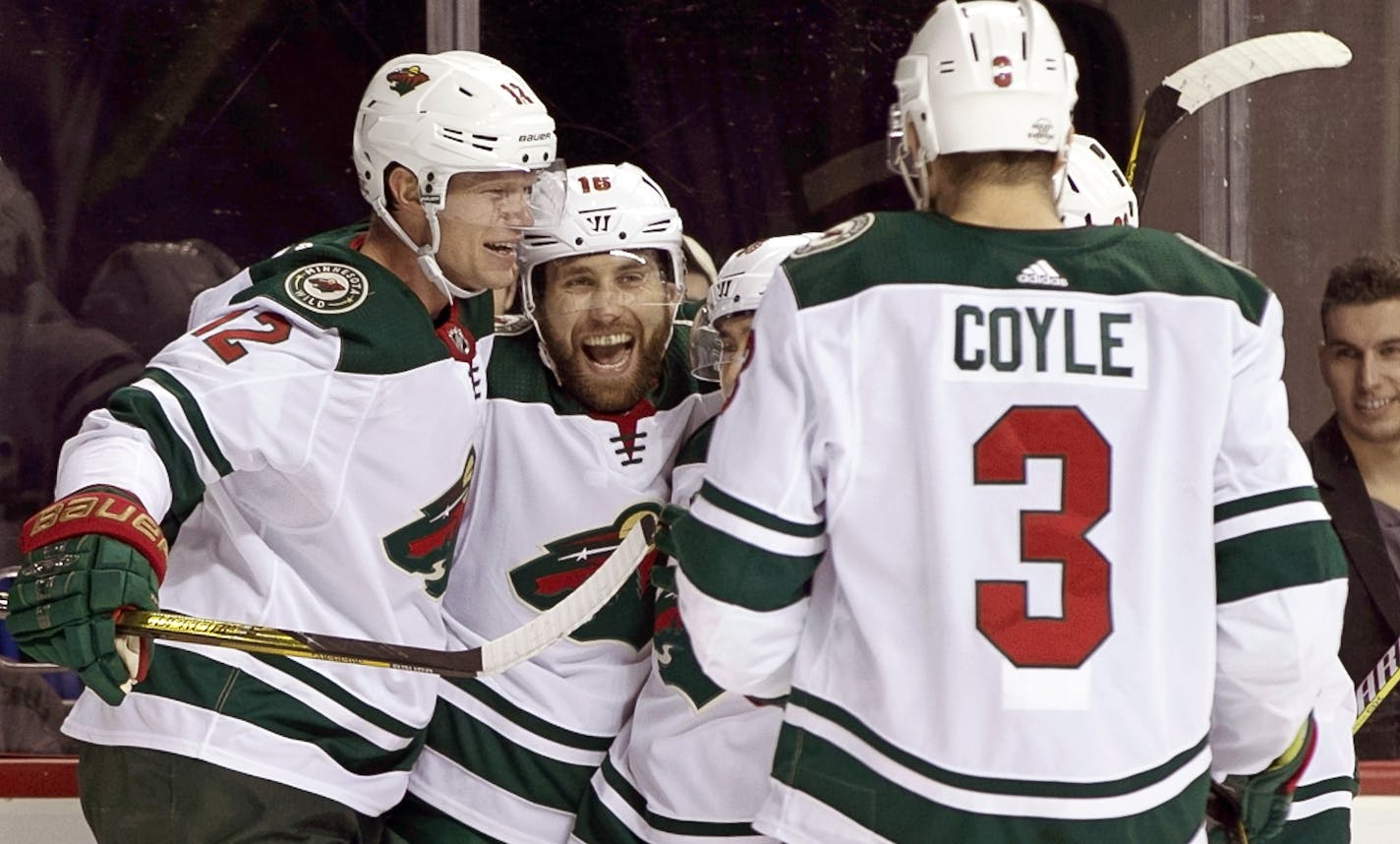 Minnesota Wild center Eric Staal (12) celebrates wtih Wild left wing Jason Zucker (16) who scored a goal on New York Islanders goaltender Jaroslav Halak during the third period of an NHL hockey game in New York, Monday, Feb. 19, 2018. Zucker scored two goals to help the Wild defeat the Islanders 5-3. Wild center Charlie Coyle (3) watches the celebration. (AP Photo/Kathy Willens)