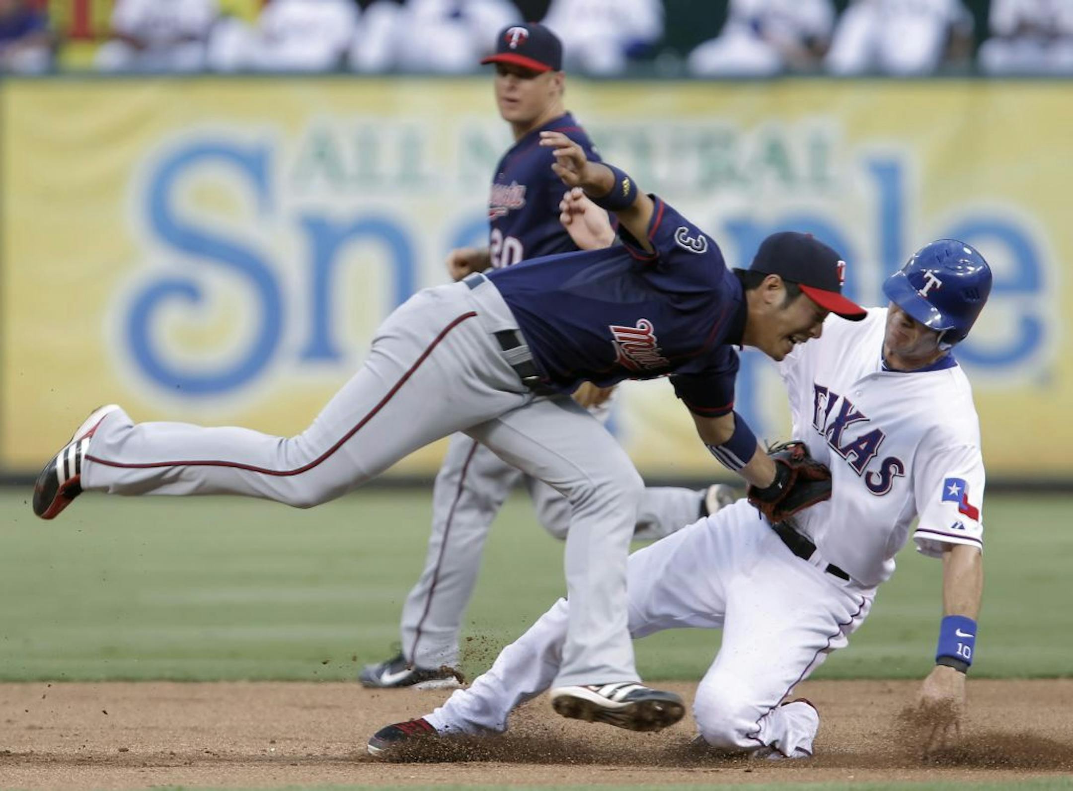 Texas' Michael Young is tagged out trying to steal second base by Minnesota shortstop Tsuyoshi Nishioka in the fourth inning.