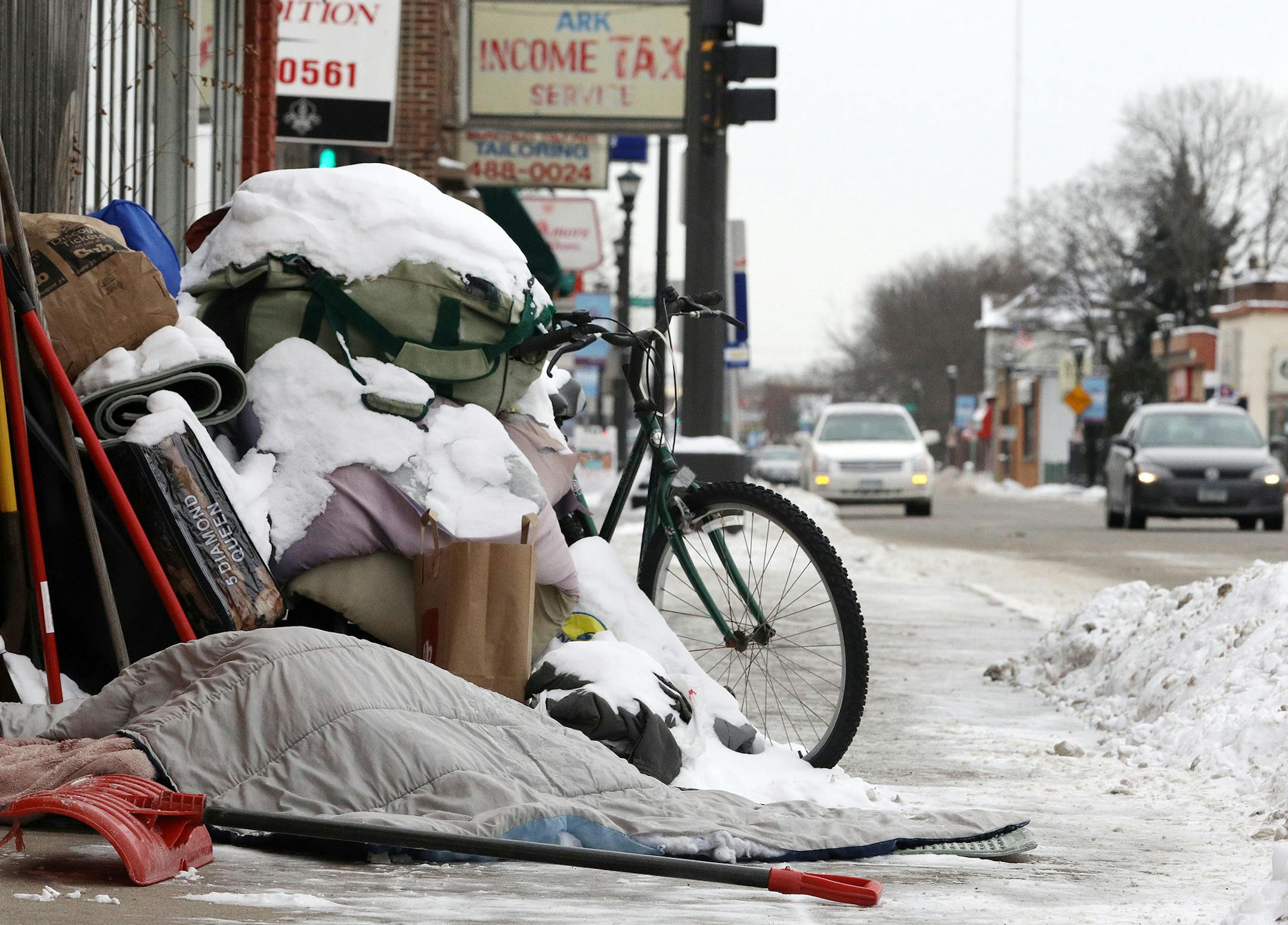 A homeless person slept under a blanket in single digit temperatures along Rice Street Friday. ] ANTHONY SOUFFLE • anthony.souffle@startribune.com Scenes from The North End along Rice Street considered is drive-through country to many Friday, Jan. 13, 2017 in St. Paul, Minn.