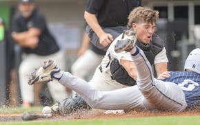 Andover’s Wyatt Myers drops the ball as Rhys George slides safely into home during the top of the first inning in the Class 4A high school baseball