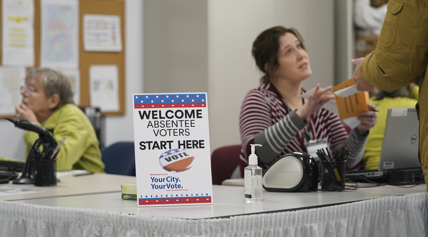 A poll worker speaks with a voter as Minneapolis Early Voting Center opened, Friday, Jan. 17, 2020, in Minneapolis. (Glen Stubbe/Star Tribune via AP)