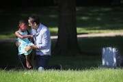 During a visit to Emily Hofher's grave site, Hofher's husband Rob Raub and their daughter Ruby Raub, 4, share a quiet moment together in July in Minne