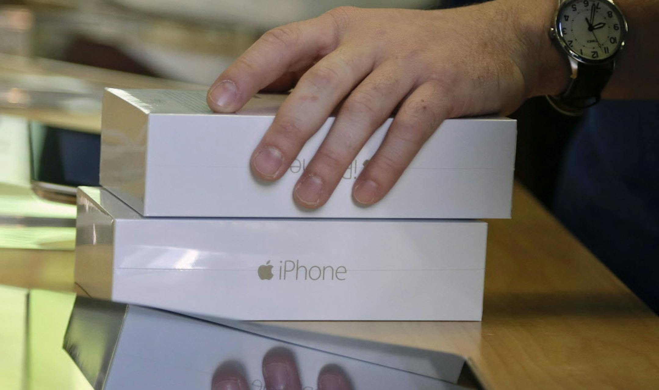 FILE - In this Sept. 19, 2014 file photo, an Apple store employee checks out a customer who bought two iPhone 6 smartphones, in New York. Apple on Monday, Oct. 20, 2014 said it sold 39.3 million iPhones in the last quarter, or 16 percent more than a year ago, which is a record for the quarter. Thatís partly due to excitement over new iPhone 6 and 6 Plus models that Apple began selling last month. (AP Photo/Julie Jacobson, File)