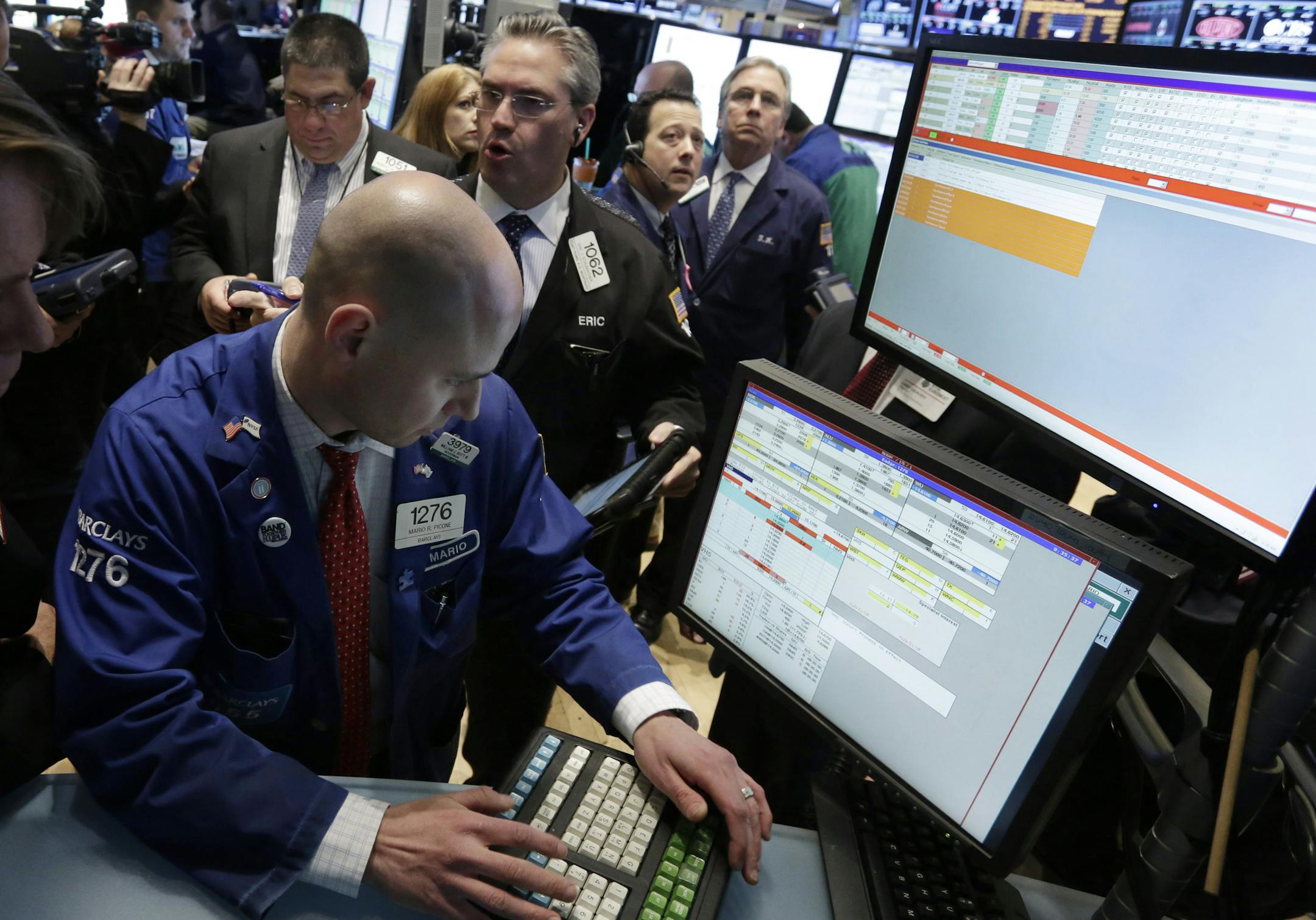 FILE - In this Monday, March 25, 2013, file photo, Specialist Mario Picone, left, works with traders at his post on the floor of the New York Stock Exchange. Renewed jitters about Europe's debt crisis sent world stock markets lower Thursday March 28, 2013. (AP Photo/Richard Drew, File)