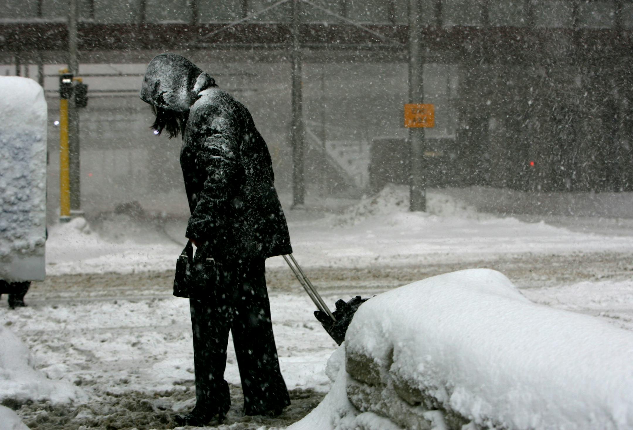DAVID JOLES � djoles@startribune.com Minneapolis, MN - March 1, 2007 -A snow-covered pedestrian crosses 5th Street at Marquette Ave. in downtown Minneapolis Thursday on the way to the busstop.