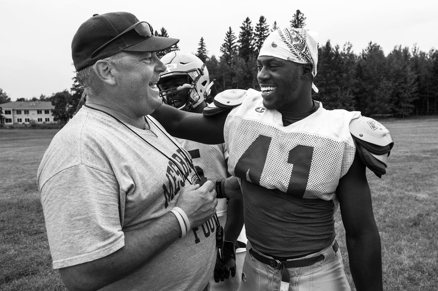 Mesabi Range College Head Coach Dan Lind shared a laugh with wide receiver Denzel Washington, from Live Oak, Florida, during a mid-August practice. ] Aaron Lavinsky &#x2022; aaron.lavinsky@startribune.com Photos to accompany a story on the Mesabi Range College Football team in Virginia, Minnesota. The team, which consists mostly of black athletes recruited from around the country, struggles to find its place in mostly-white mining country on the Iron Range.