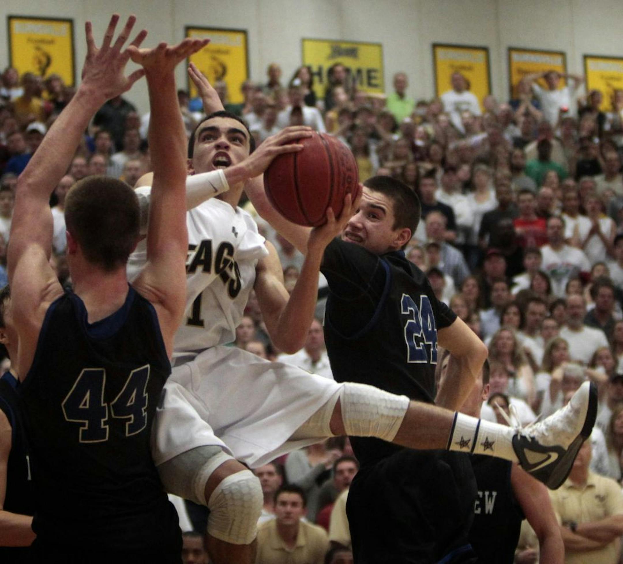 Apple Valley's Tyus Jones looked for an open shot between Eastview's Ben Oberfeld (left) and Joey King (right). Eastview won the game 57-53 to win the Class 4A, Section 3 boys' basketball title and earn a spot in the state tournament.