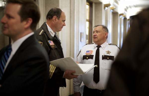 Hennepin County Sheriff Rich Stanek, left background, and Carver County Sheriff Jim Olson talked in a hallway before laying out concerns about gun bac