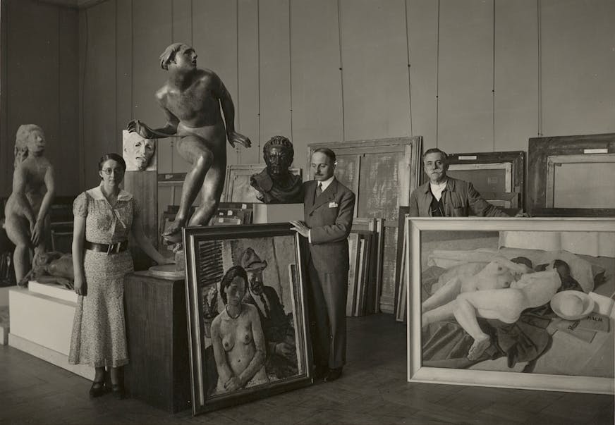 photo of three people and many artworks