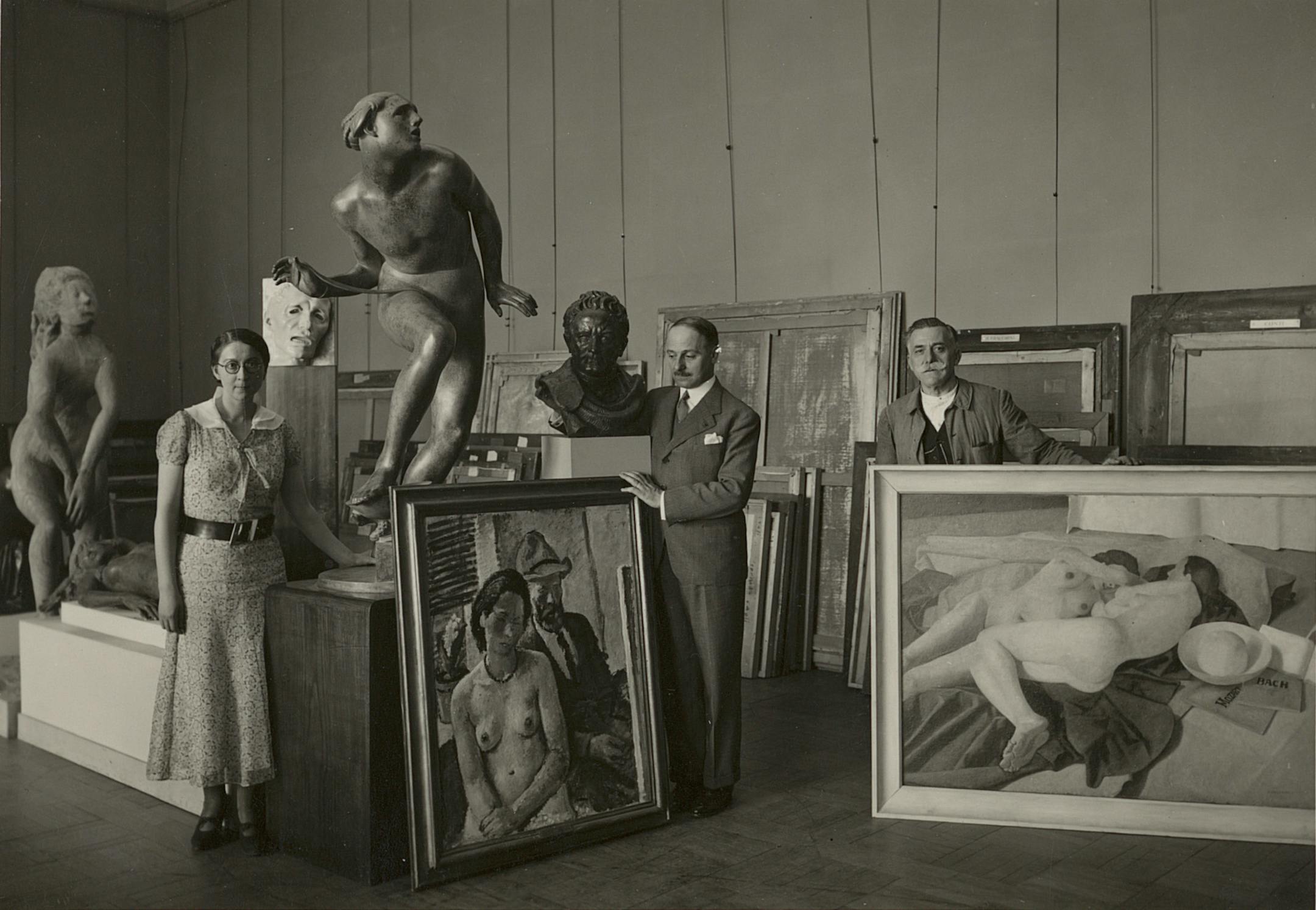 photo of three people and many artworks