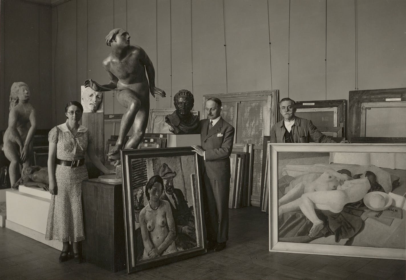 photo of three people and many artworks