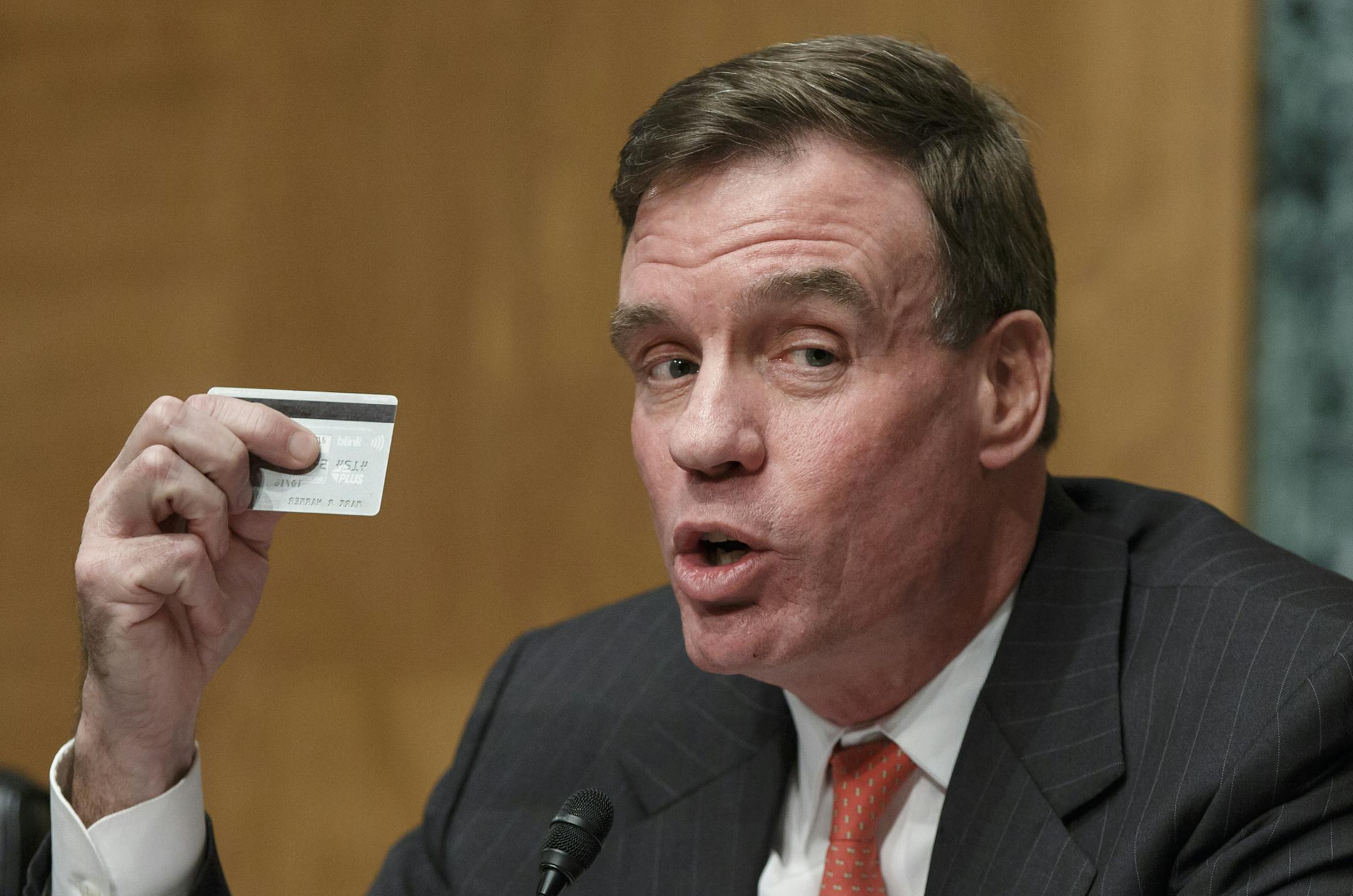 Sen. Mark Warner, D-Va., chairman of the Senate Banking Subcommittee on National Security and International Trade and Finance, displays his personal bank card as he leads a hearing on the recent incidents of mass credit card fraud following the theft of consumers&#xed; data at retailers such as Target Corp and Neiman Marcus during the holiday shopping season, on Capitol Hill in Washington, Monday, Feb. 3, 2014. Hackers stole about 40 million debit and credit card numbers and also took personal i