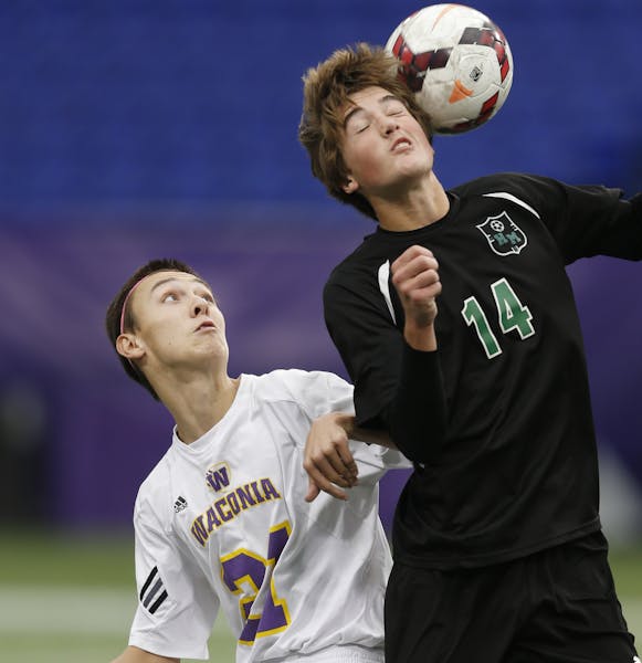 At the Metrodome in a match between 1A boys Hill-Murray and Waconia, Waconia's Anthon Shuster(21) watches as Henry Ventura(14) goes for a header. ]ric