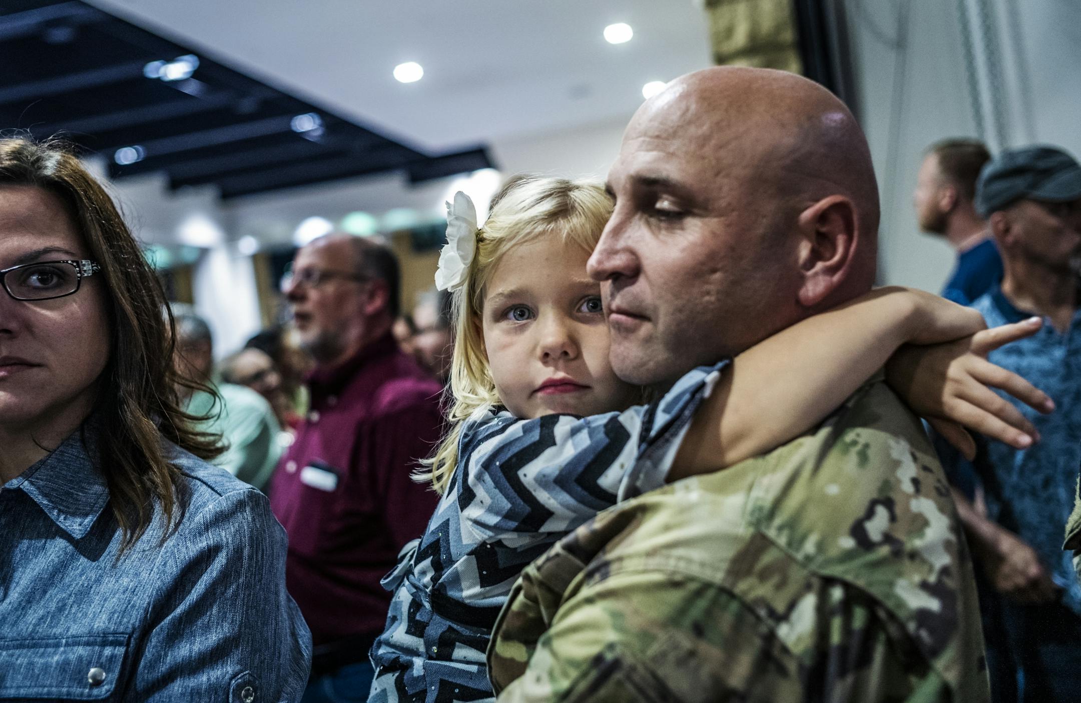 Corrina Eslinger,5, held on tight to her father, Charles, who is a major as they filed in to join a dinner for the soldiers and their families.