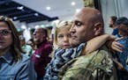 Corrina Eslinger,5, held on tight to her father, Charles, who is a major as they filed in to join a dinner for the soldiers and their families.