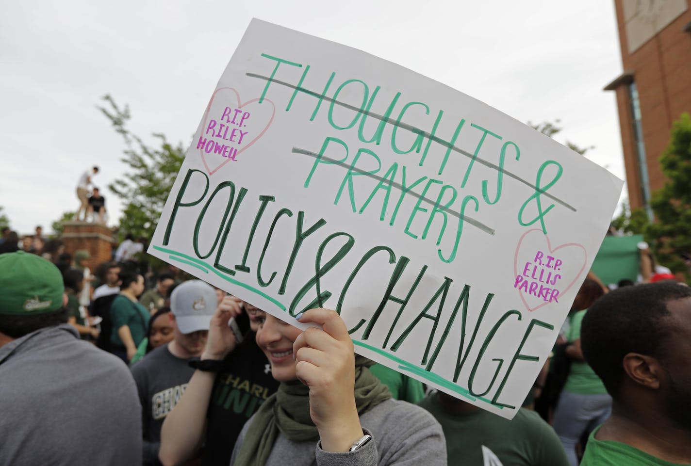 A student carries a sign as she leaves a vigil at the University of North Carolina-Charlotte in Charlotte, N.C., Wednesday, May 1, 2019 after a student with a pistol killed two people and wounded four others on Tuesday. (AP Photo/Chuck Burton)