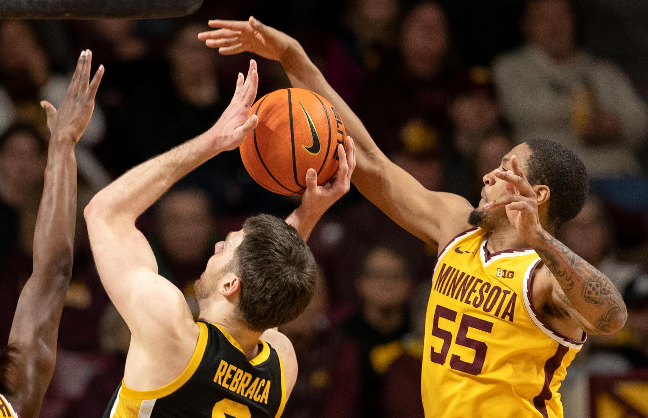 Ta'Lon Cooper (55) of the Minnesota Gophers blacks a shot by Filip Rebraca (0) of the Iowa Hawkeyes in the first half.