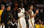 Minnesota Golden Gophers center Bakary Konate (21) and Minnesota Golden Gophers guard Amir Coffey (5) clapped along with their teammates as they watch