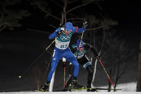 Leif Nordgren, of the United States, climbs ahead Kauri Koiv, of Estonia, during the men's 10-kilometer biathlon sprint at the 2018 Winter Olympics in