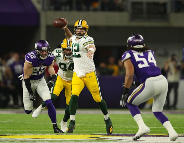 Packers quarterback Aaron Rodgers looked for a receiver in the first quarter with Vikings safety Harrison Smith in pursuit