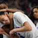 Hopkins guard Raena Suggs (3) put guard Amaya Battle (5) in a playful headlock as they celebrated their team's 61-34 win over Roseville Thursday.