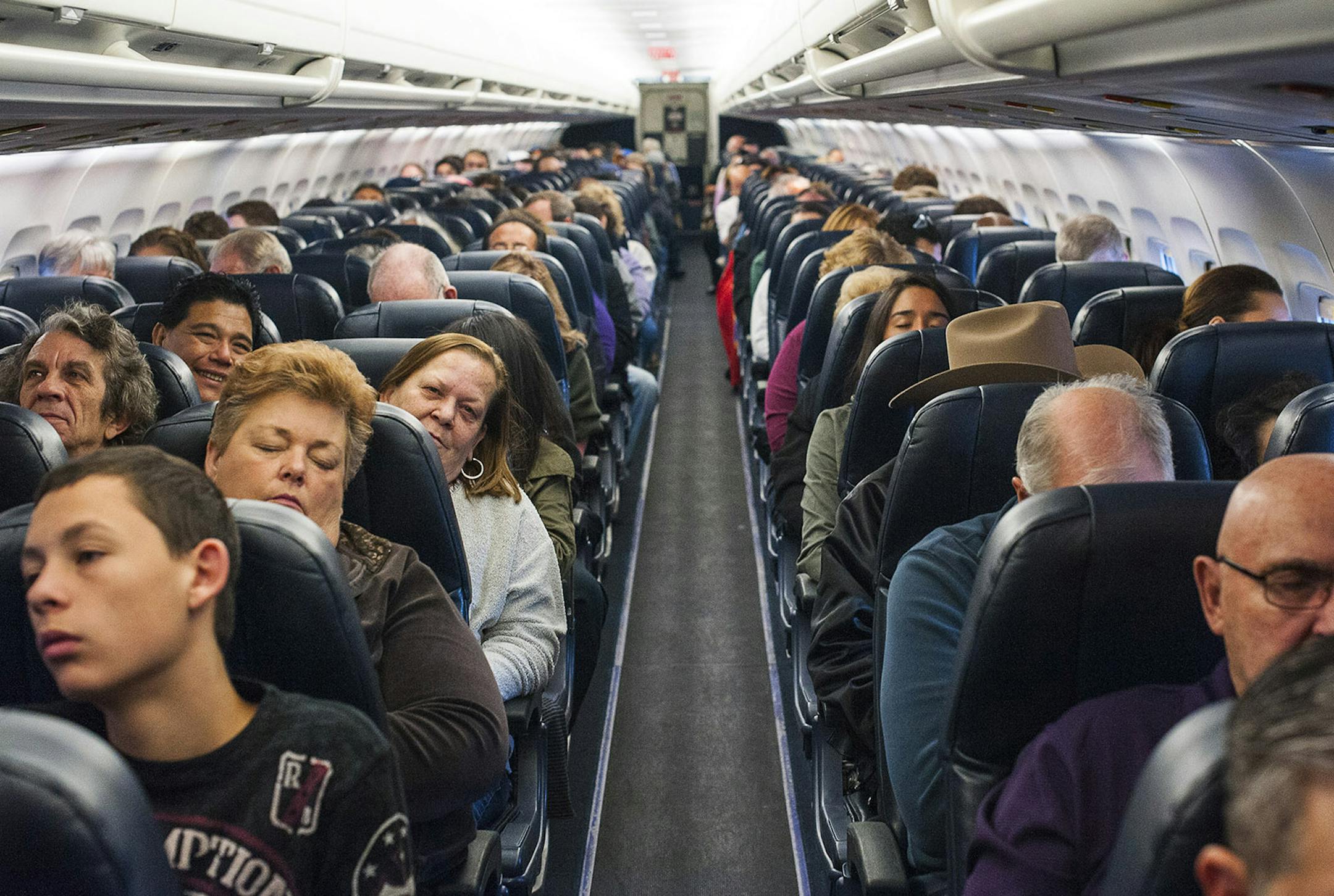 Passengers aboard an Allegiant Airlines flight en route from Las Vegas to Colorado Springs, Colo., Dec. 19, 2013. To gain a little more space between seats in the continuing push to add passengers, airlines like Allegiant, which uses seats that do not recline, are turning to a new generation of seats that use lighter materials and less padding. (Joe Giron/The New York Times) ORG XMIT: MIN2013122315411997