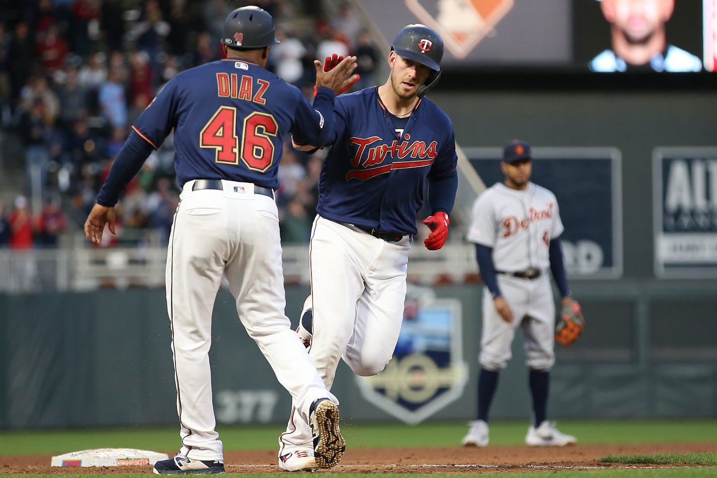 The Twins' Mitch Garver high-fives third base coach Tony Diaz after he hit a home run against the Tigers during the fourth inning