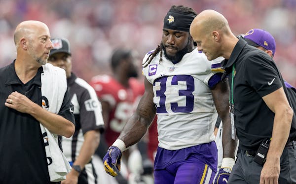 Minnesota Vikings running back Dalvin Cook (33) walked off the field with trainers.