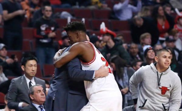 Chicago Bulls' Jimmy Butler, center, hugs Minnesota Timberwolves' head coach Tom Thibodeau, left, hugged before their game last December in Chicago.