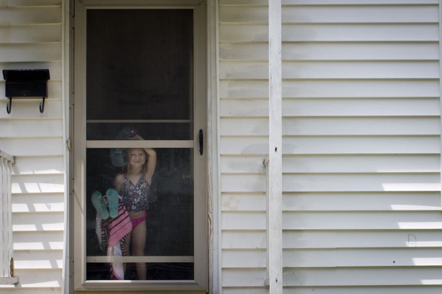 Ava Mulligan looked out the door of her house on Friday, June 29, 2012 in Minneapolis, Minn., a few blocks from where a 5-year-old boy was shot asleep on the couch in his house. Ava's mom hears what she thinks is gun shots regularly south of their house.