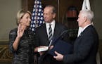 Education Secretary Betsy DeVos, with her husband, Dick DeVos, holding the bible, is sworn in by Vice President Mike Pence at the White House in Washi