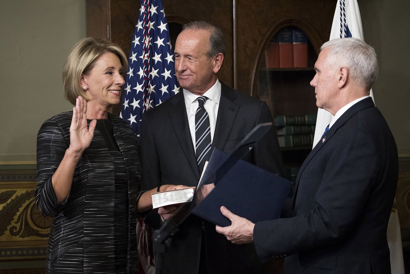 Education Secretary Betsy DeVos, with her husband, Dick DeVos, holding the bible, is sworn in by Vice President Mike Pence at the White House in Washington, Feb. 7, 2017. Sen. Susan Collins (R-Maine) and Sen. Lisa Murkowski (R-Alaska) earlier joined Democrats in rejecting DeVos, forcing Vice President Pence to cast a historic tie-breaking vote. (Doug Mills/The New York Times)