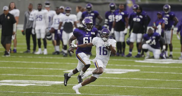 Minnesota Vikings wide receiver Cayleb Jones (16) avoids the tackle of defensive end Ade Aruna (61) at a night practice during training camp at TCO Pe