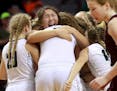 Roseau players celebrate at the end of their 75-64 victory over Sauk Centre during the girls' basketball state tournament, Class 2A championship Satur