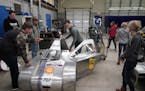 Student Joshua Klingensmith, center, readied his shop class' electric car for a test drive. The class has placed second in the world in supermileage c