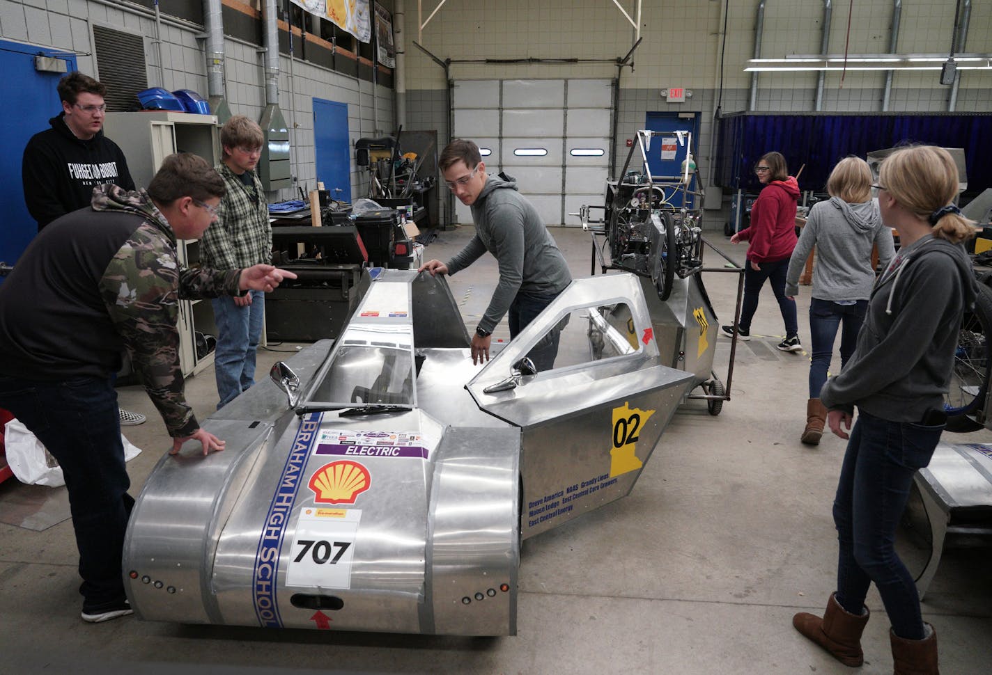 Student Joshua Klingensmith, center, readied his shop class' electric car for a test drive. The class has placed second in the world in supermileage competitions.