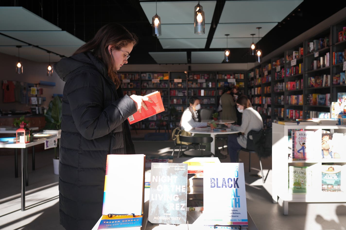 Hannah Reichenback from Minneapolis pages through a book while shopping inside Black Garnet Books on Small Business Saturday in St. Paul, Minn., on Saturday, Nov. 26, 2022. ] SHARI L. GROSS • shari.gross@startribune.com