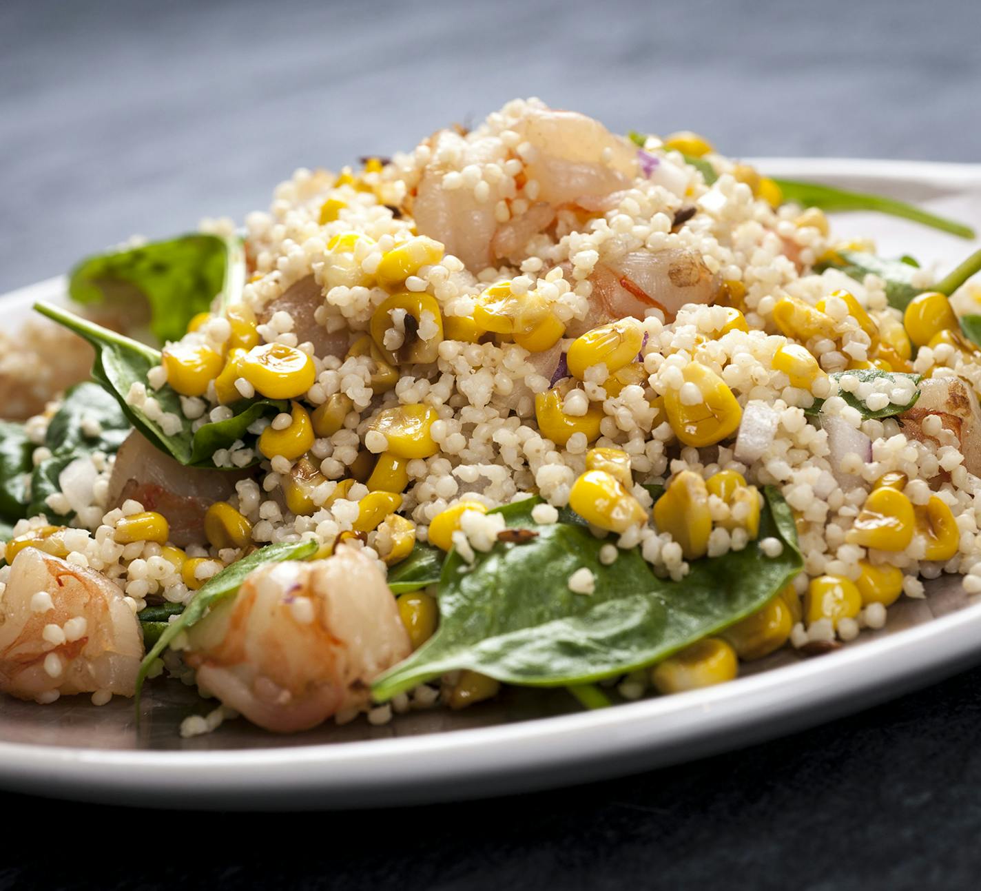 A dish of cooked millet with corn, mango and shrimp, in New York, July 16, 2013. The trick to making a good whole-grain dish is not letting the grain stand alone. (Karsten Moran/The New York Times) ORG XMIT: XNYT24