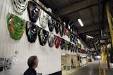 Engine hoods from various Arctic Cat snowmobiles manufactured over the years hang on a wall at Arctic Cat's munufacturing facility Wednesday, May 15, 2013 in Thief River Falls, MN. The snowmobile giant employs about 1,300 workers in Thief River Falls.