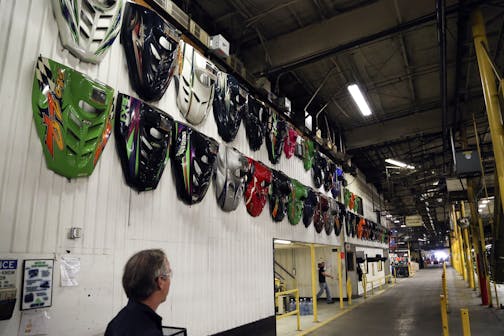 Engine hoods from various Arctic Cat snowmobiles manufactured over the years hang on a wall at Arctic Cat's munufacturing facility Wednesday, May 15, 2013 in Thief River Falls, MN. The snowmobile giant employs about 1,300 workers in Thief River Falls.