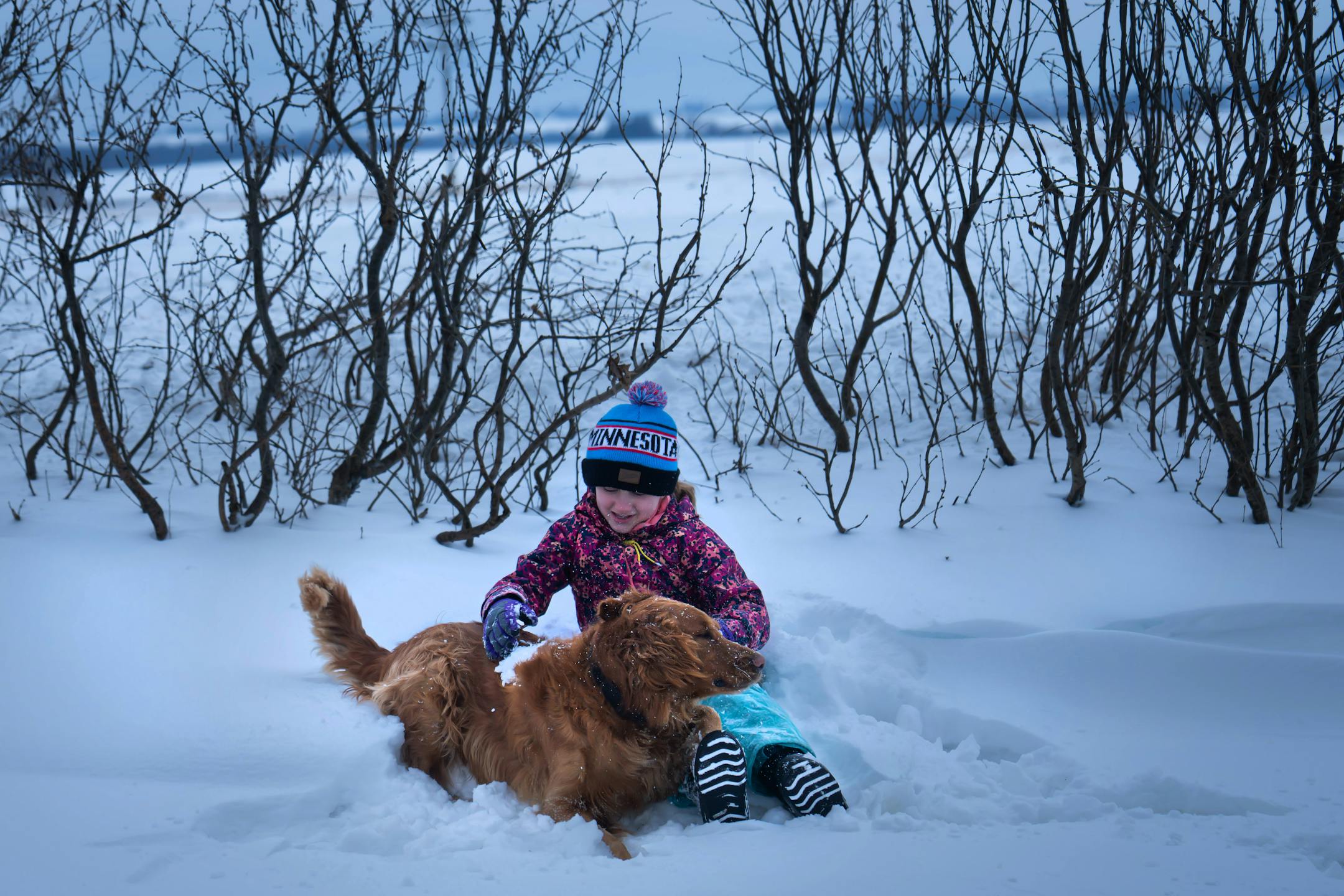 Ellie Johnson, 9, played with the family dog Parker, in the snow outside their home.