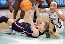 UConn guard Paige Bueckers passed under pressure from South Carolina forward Victaria Saxton during Sunday's championship game at Target Center.