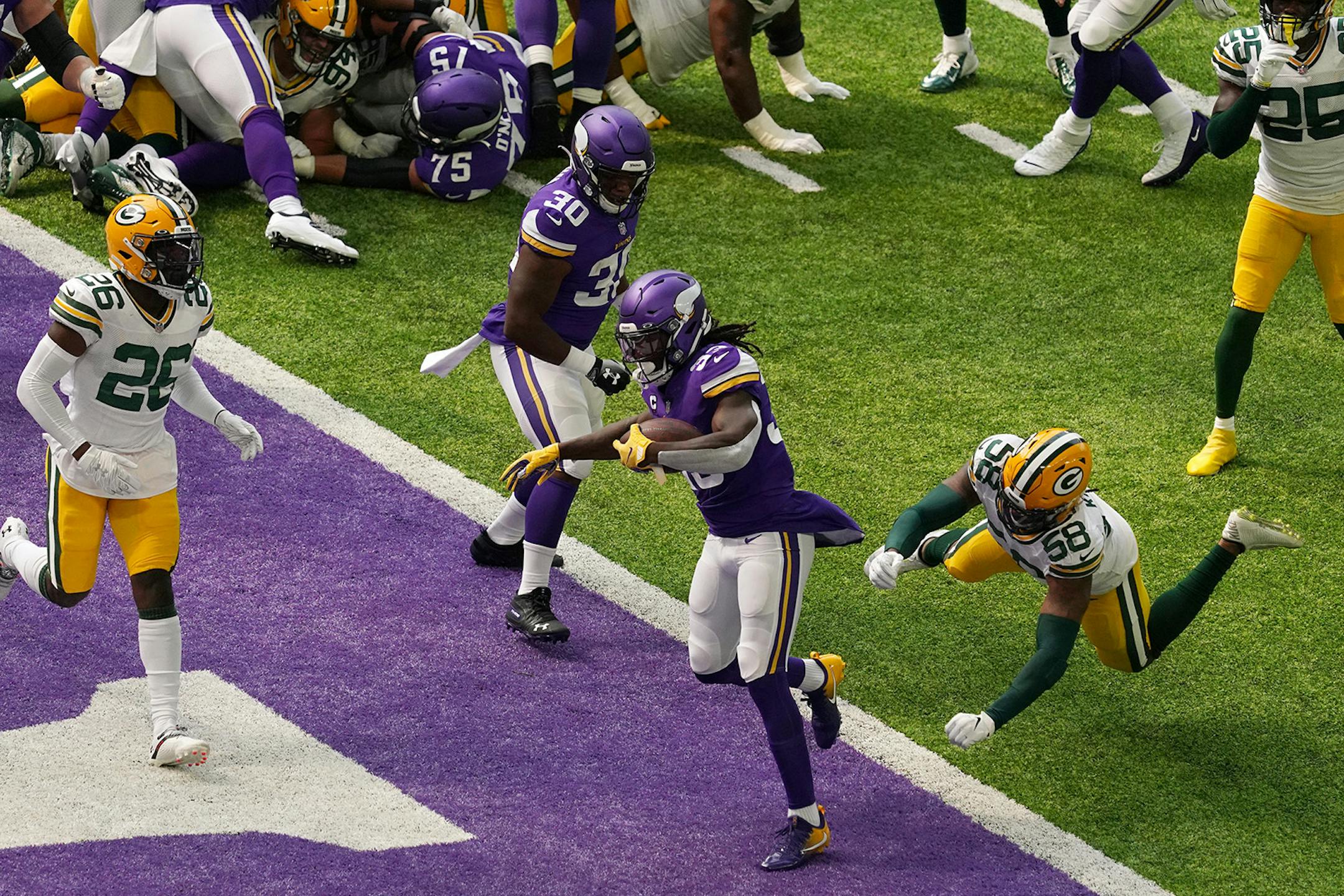 Minnesota Vikings running back Dalvin Cook (33) ran the ball into the end zone past the tackle by Green Bay Packers outside linebacker Christian Kirksey (58) for a touchdown in the first quarter.