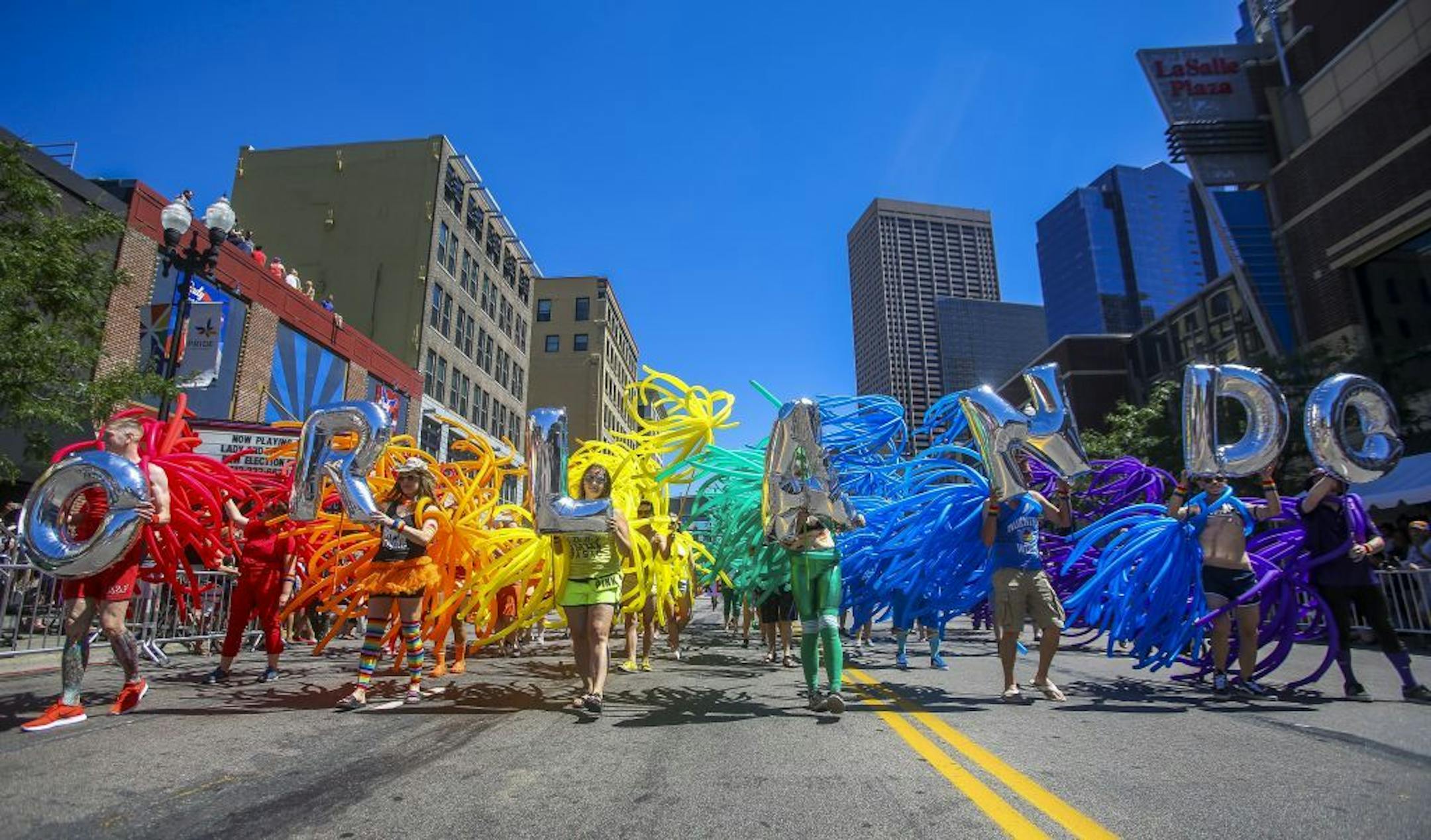 Inflated balloons spelling "Orlando" are followed by an array of inflated balloons that created a rainbow at the Twin Cities Pride parade on Sunday in Minneapolis.
