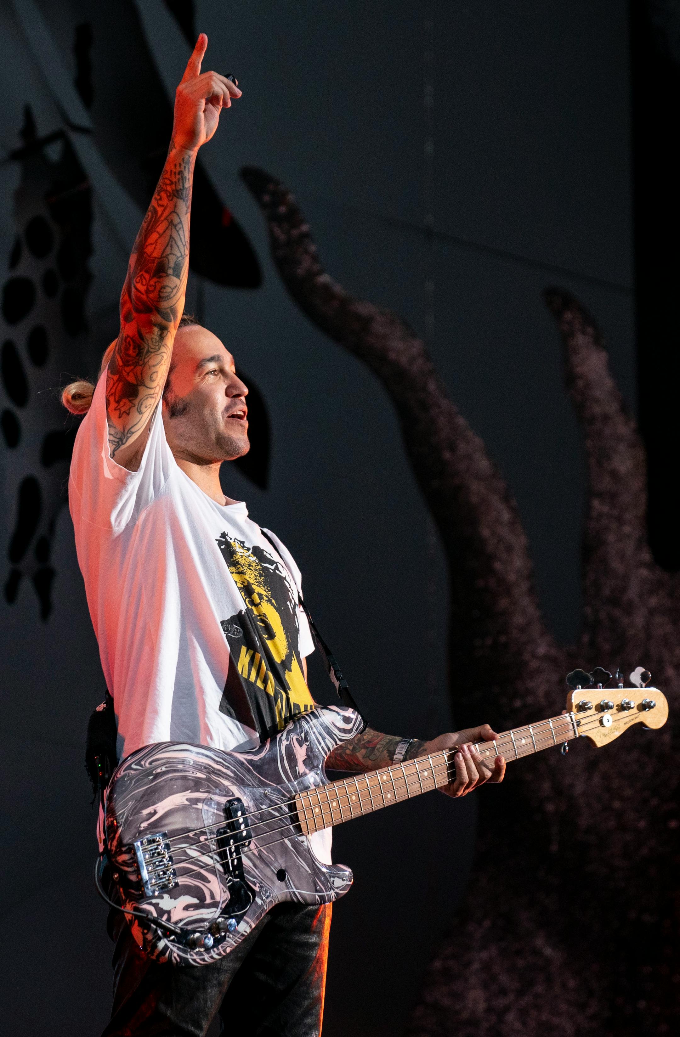 Pete Wentz, bassist for Fall Out Boy, pointed to the sky during the band's set at the Hella Mega Tour at Target Field in Minneapolis on Monday.