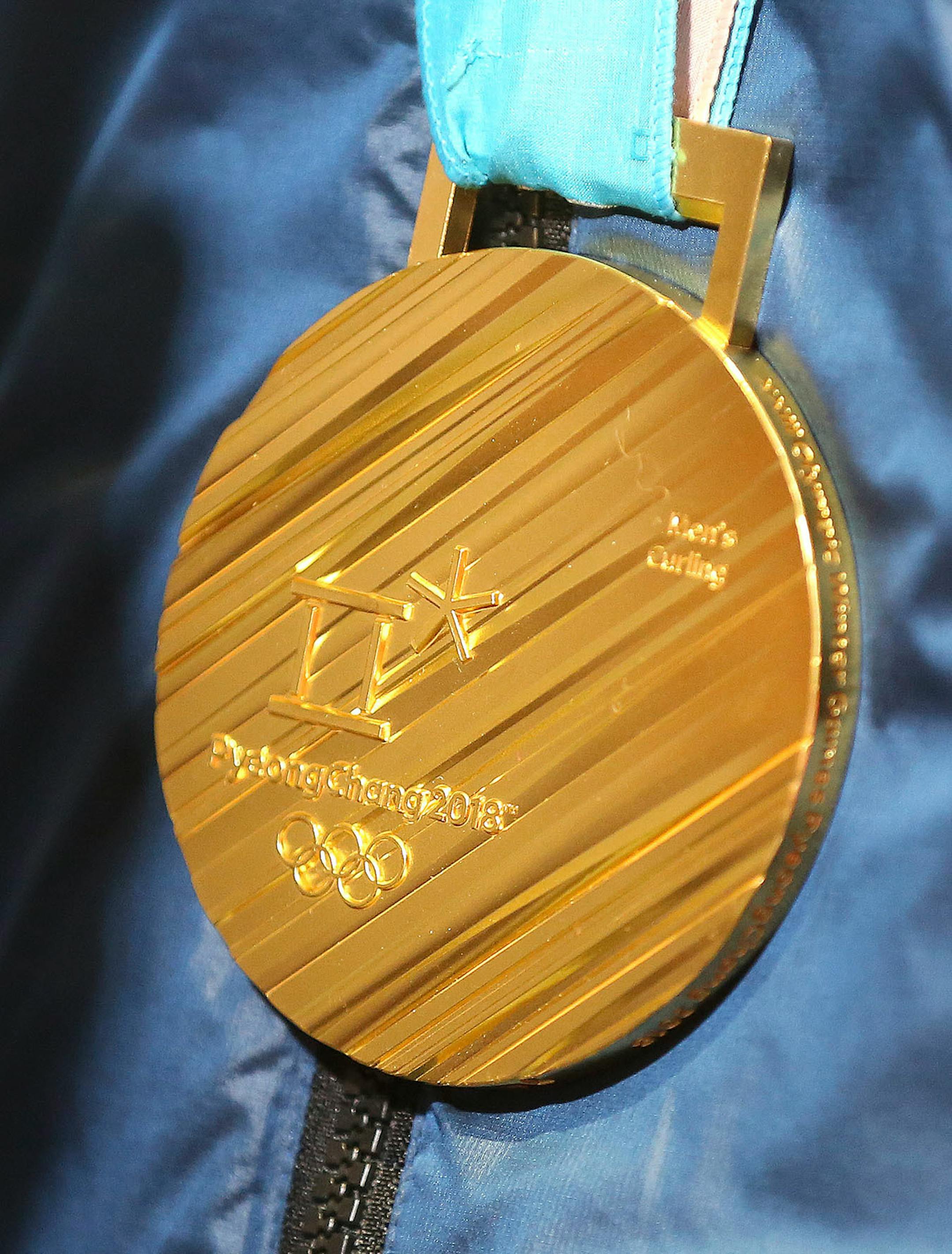 John Shuster wears the his gold medal for Men's Curling around his neck at the airport Monday. Bob King / rking@duluthnews.com
