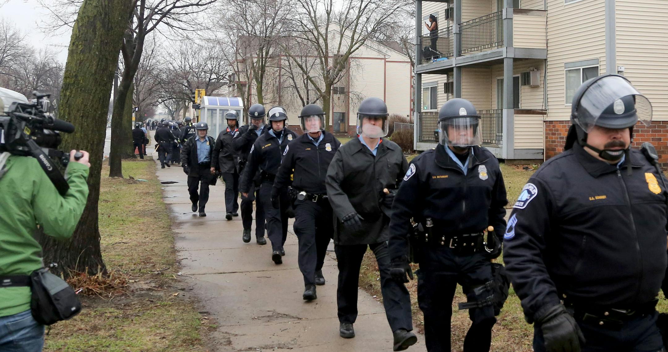 Police in riot gear head back toward the 4th precinct after being dispatched to head to the 1600 block of Plymouth Ave. N, where protesters had shut down the street Wednesday, March 30, 2016, in Minneapolis, MN.]STARTRIBUNE)djoles@startribune.com With a decision on charging of Minneapolis police officers in the shooting of Jamar Clark, rain falls on the memorial to Clark as an emergency vehicle passes along Plymouth Ave. N. Wednesday, March 30, 2016, in Minneapolis, MN. Clark was killed in Novem