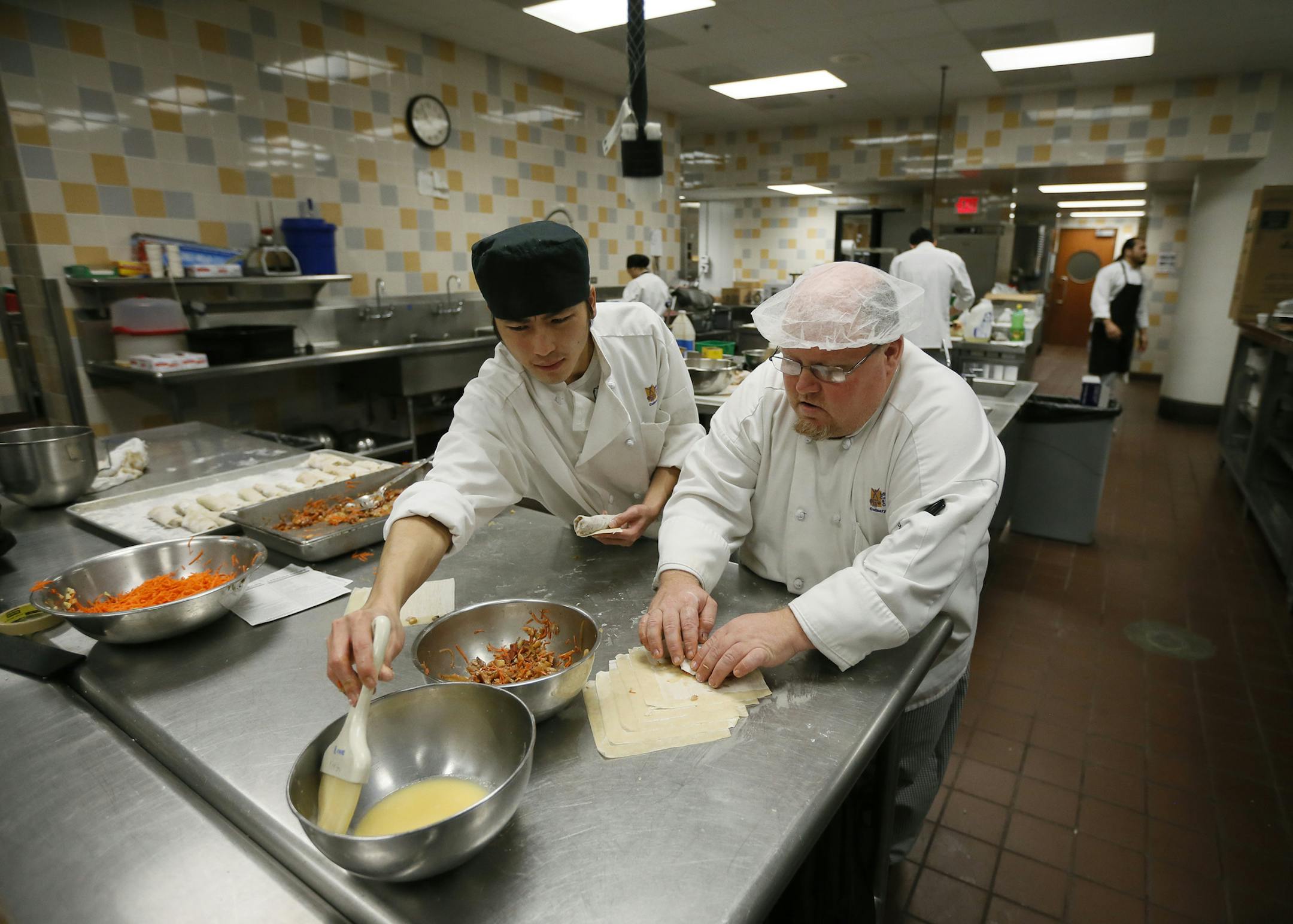 Yeng Yang left and Zach Barnes made egg rolls during class at Minneapolis Community & Technical College ,the college is on the verge of dropping the culinary arts program.Thursday October 23 , 2014 in Minneapolis ,MN. ] Jerry Holt Jerry.holt@startribune.com