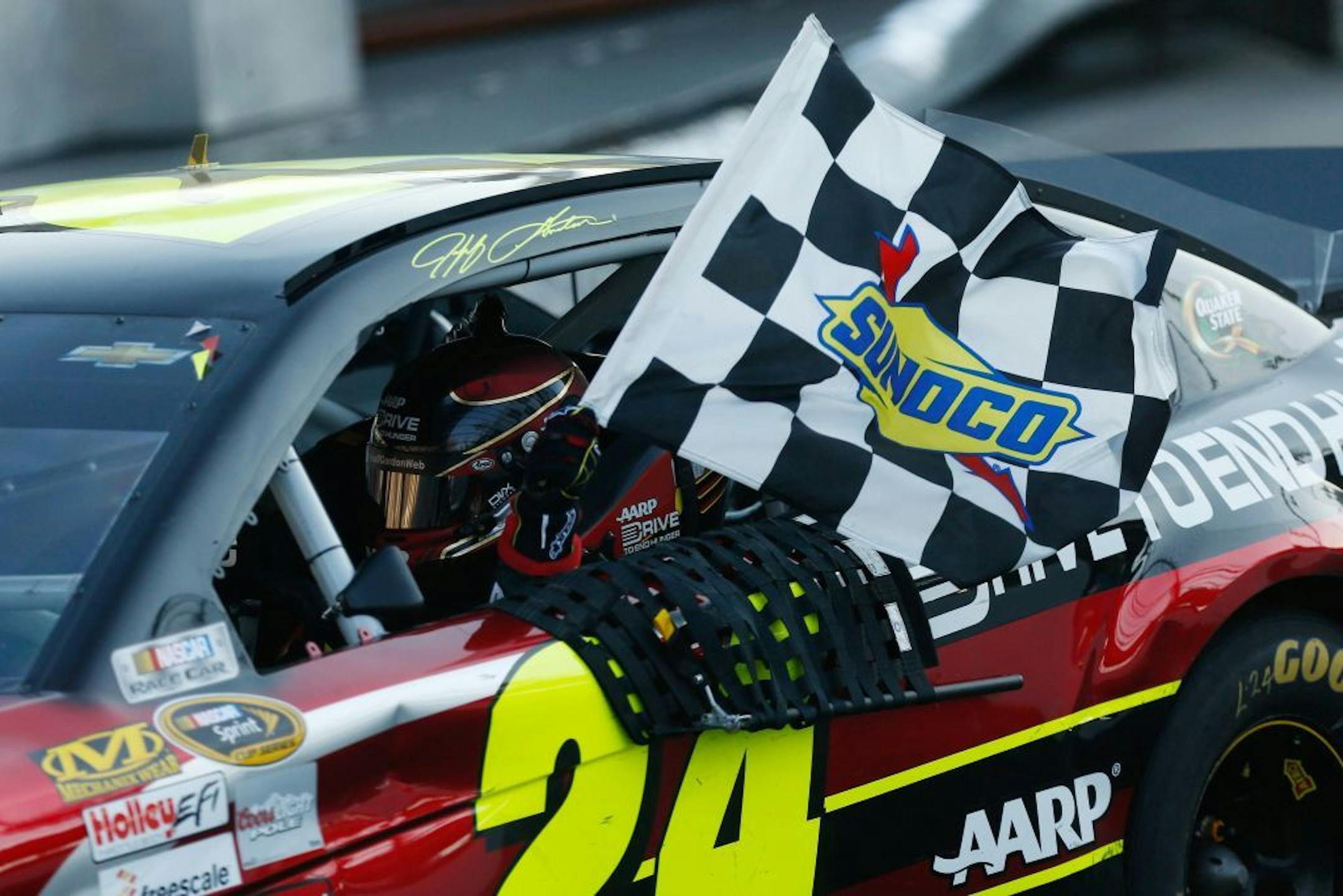 Jeff Gordon (24) holds the checkered flag as he celebrates winning the NASCAR Sprint Cup auto race at Martinsville Speedway Sunday, Oct. 27, 2013, in Martinsville, Va.