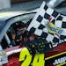 Jeff Gordon (24) holds the checkered flag as he celebrates winning the NASCAR Sprint Cup auto race at Martinsville Speedway Sunday, Oct. 27, 2013, in 